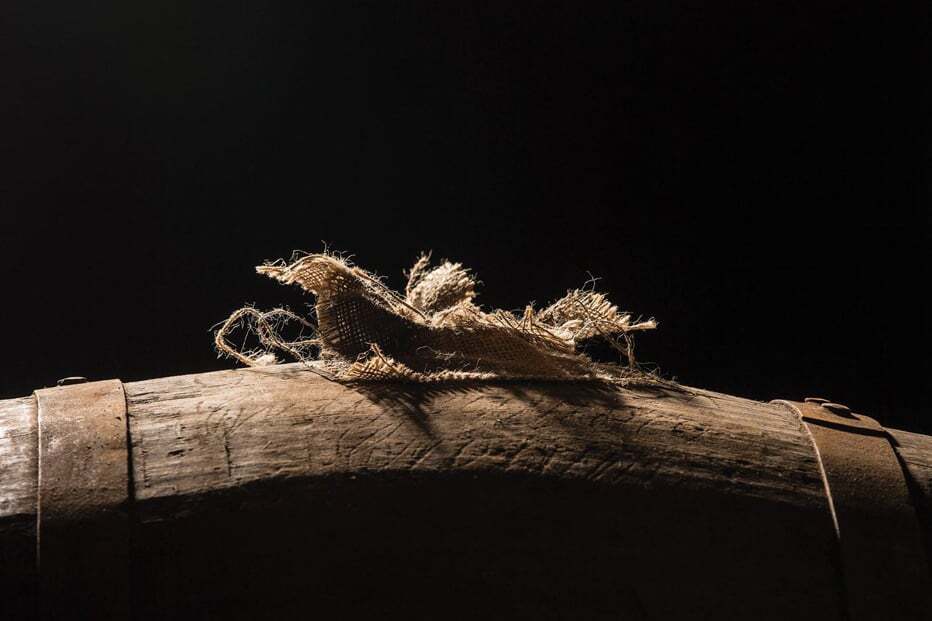 A close up of a cask on its side in a Gordon and MacPhail whisky warehouse
